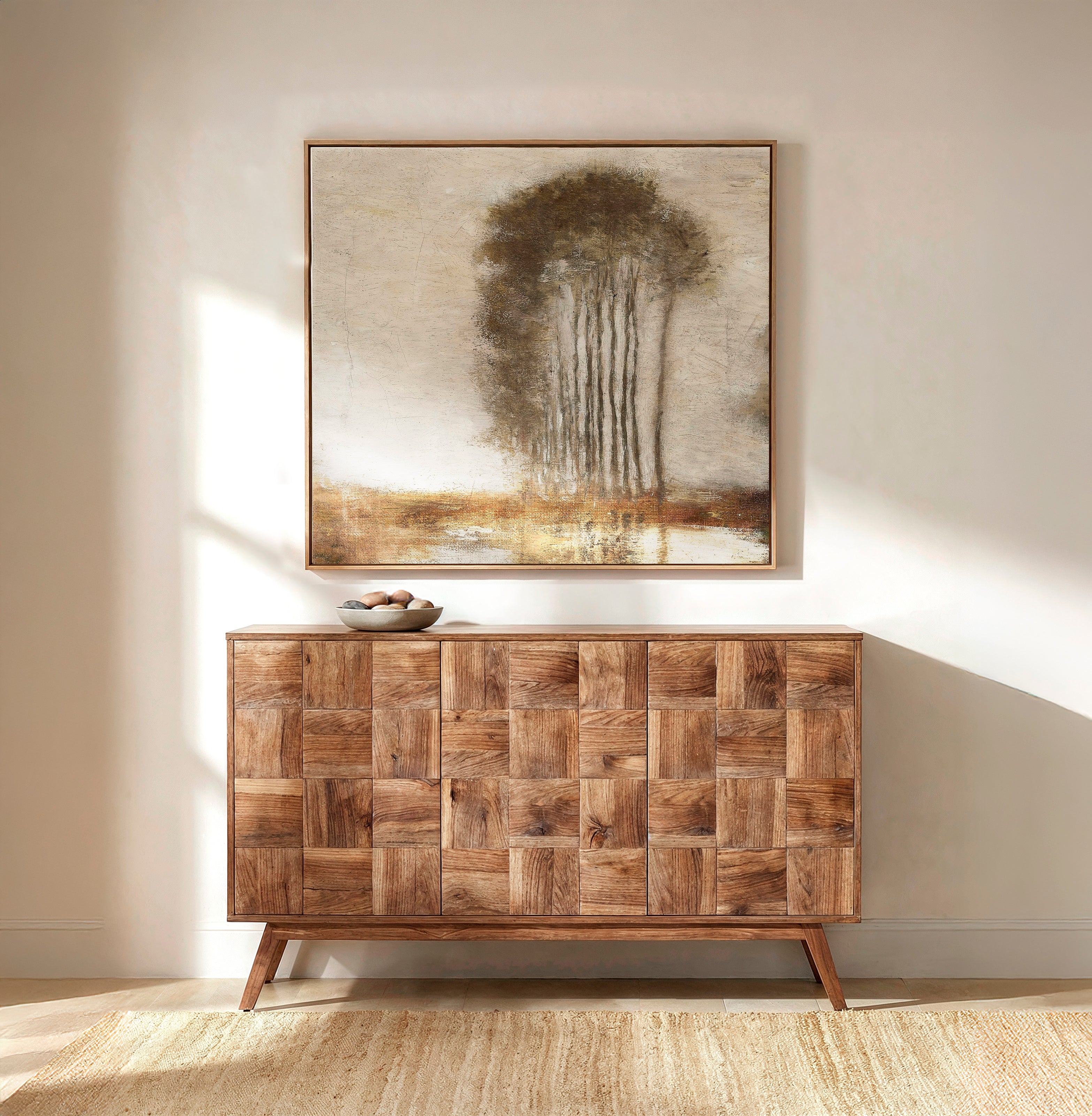 Wooden sideboard with patchwork design below a large abstract painting on a beige wall.